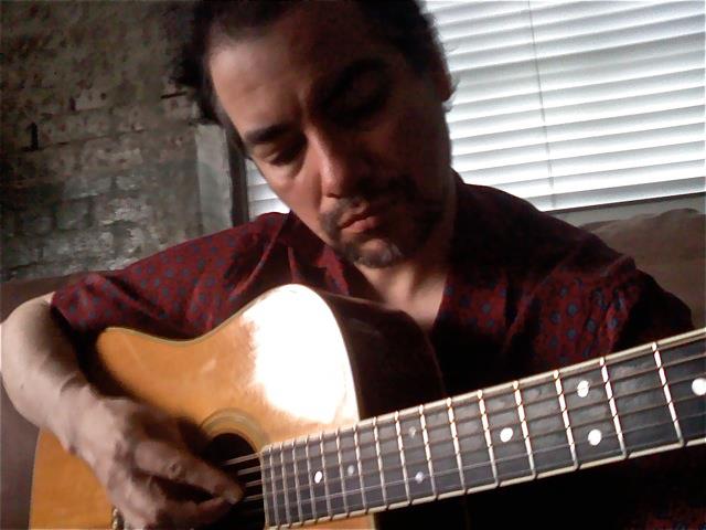 Kevin Corrigan playing guitar